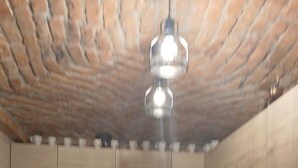 A kitchen with wooden cabinets, a gas stove, and a hanging light fixture.