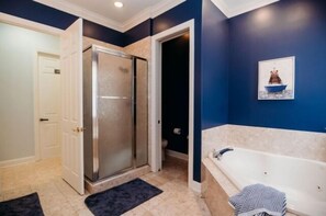 Une salle de bain avec une douche, une baignoire et des toilettes.