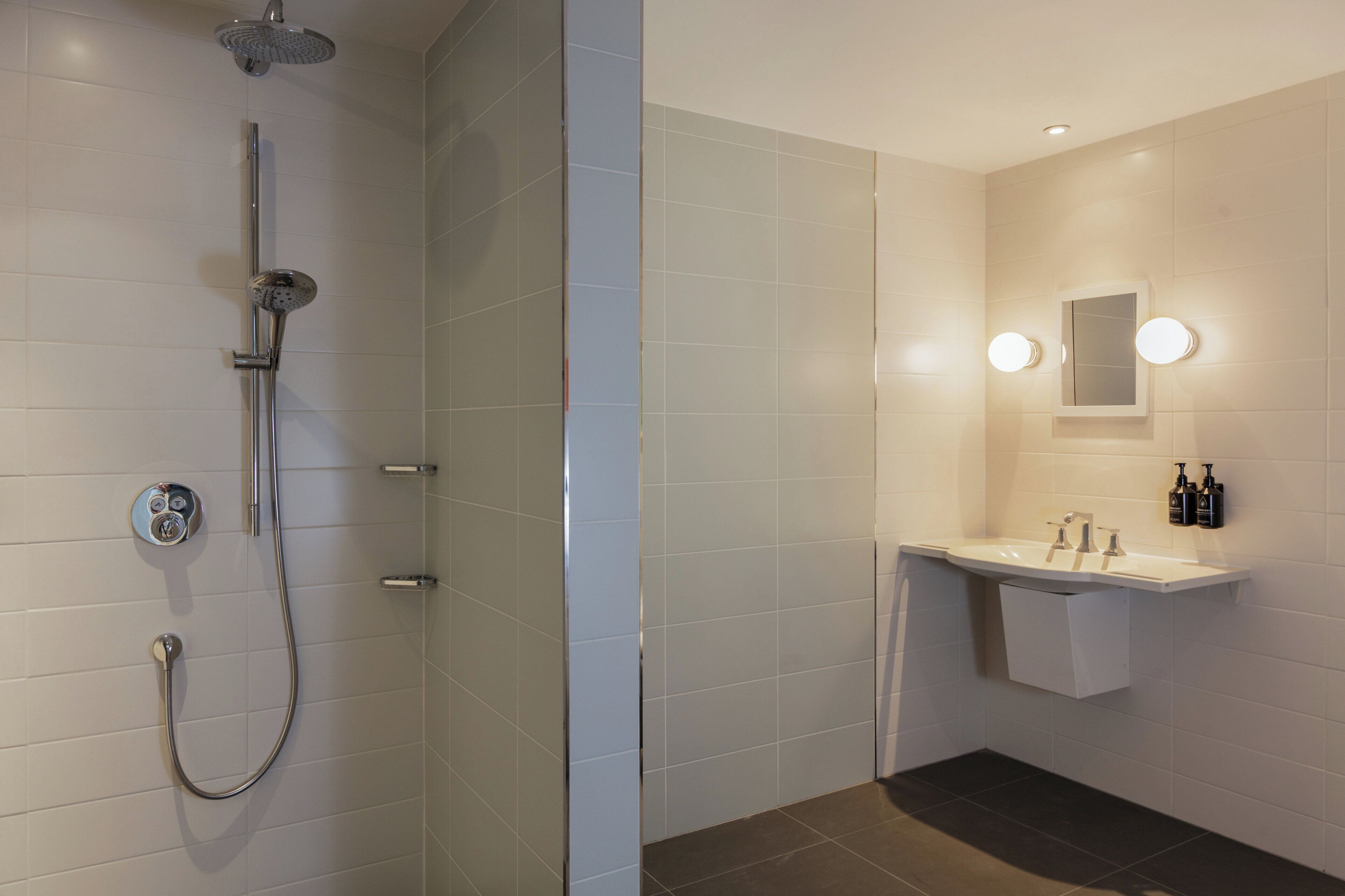 Une salle de bain moderne avec une douche, un lavabo et un miroir.
