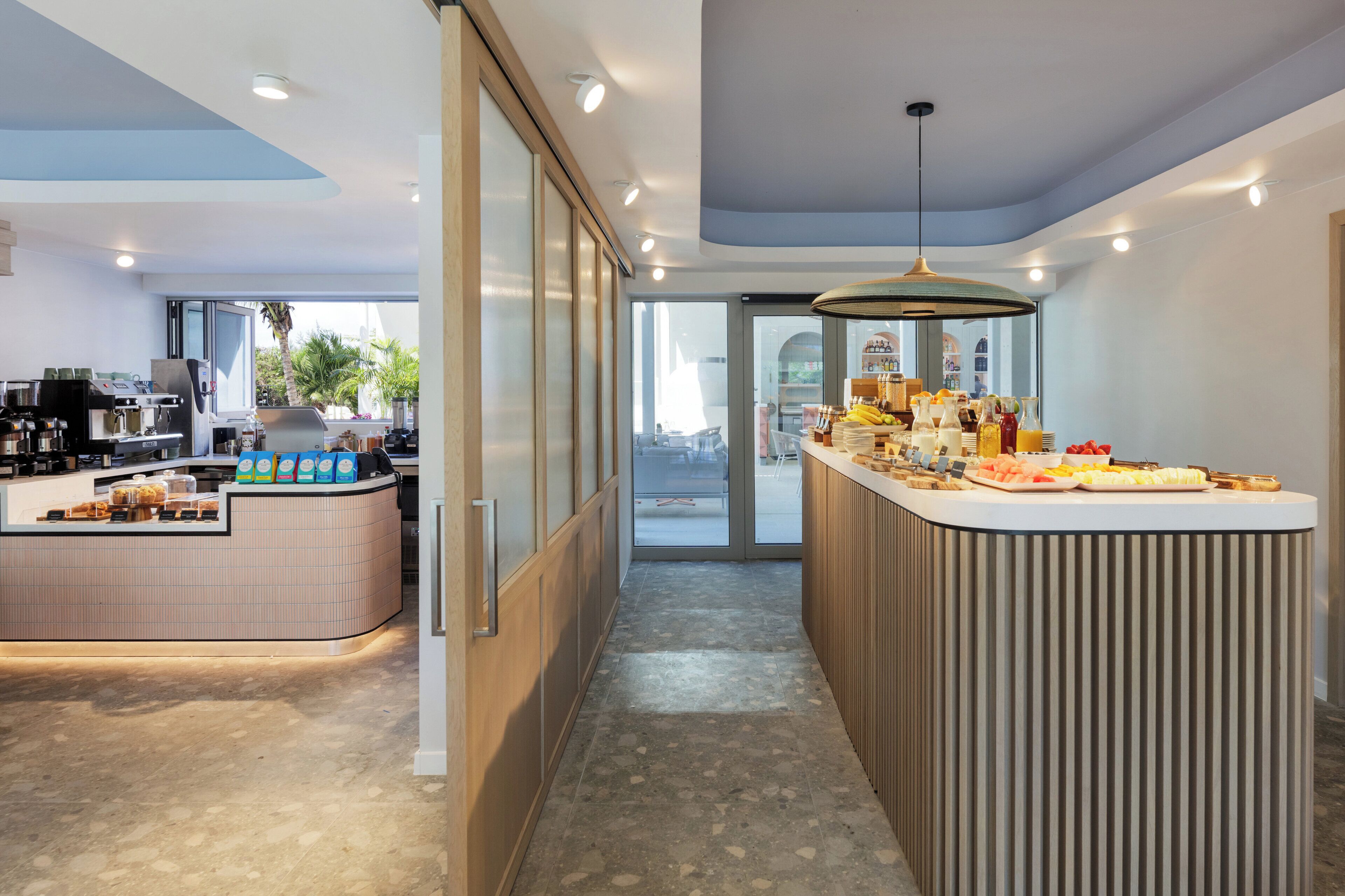 A modern kitchen area with a coffee station and a breakfast bar.