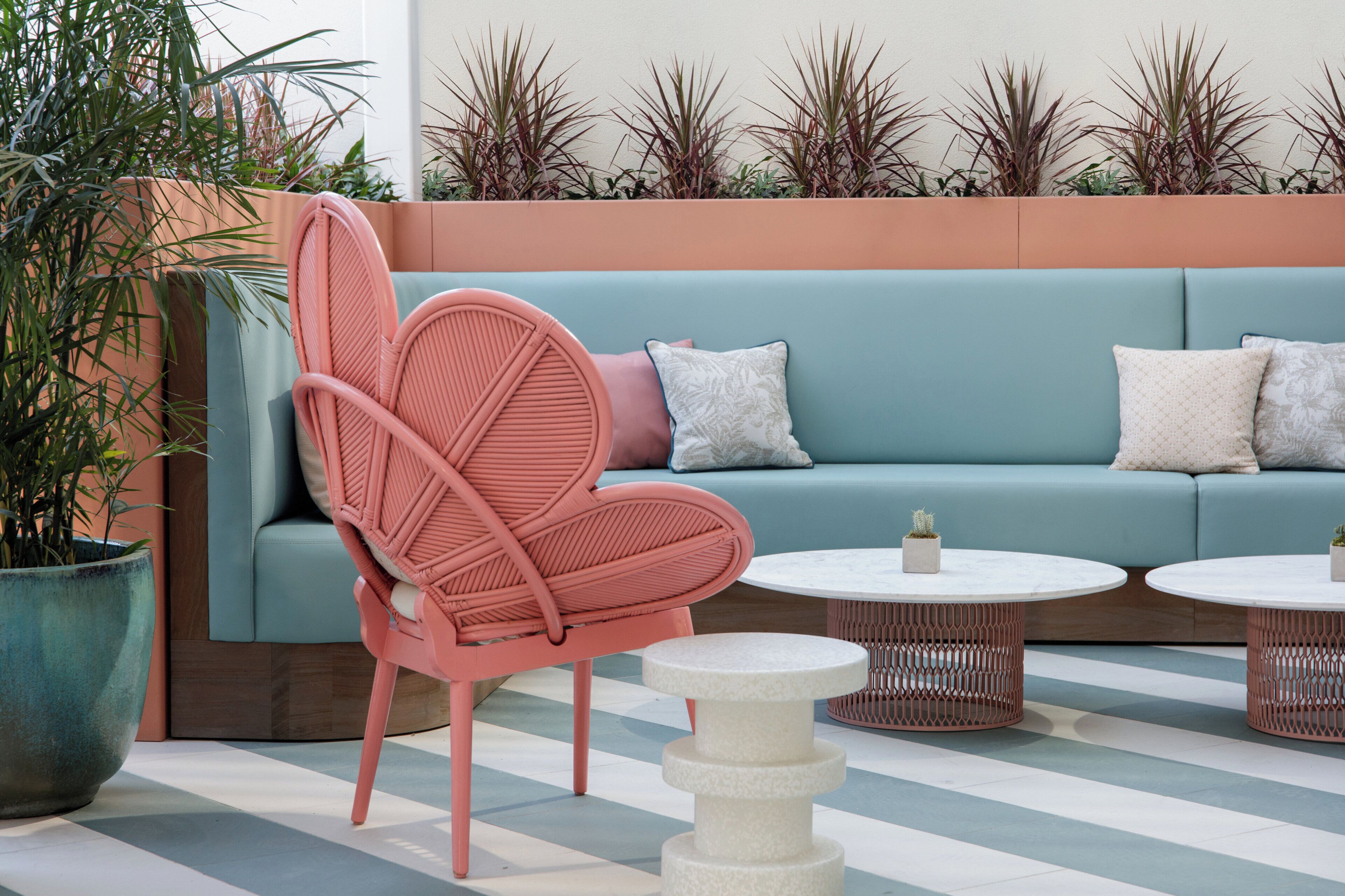 A seating area with a sofa, a chair, and two round tables.
