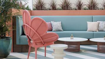 A seating area with a sofa, a chair, and two round tables.