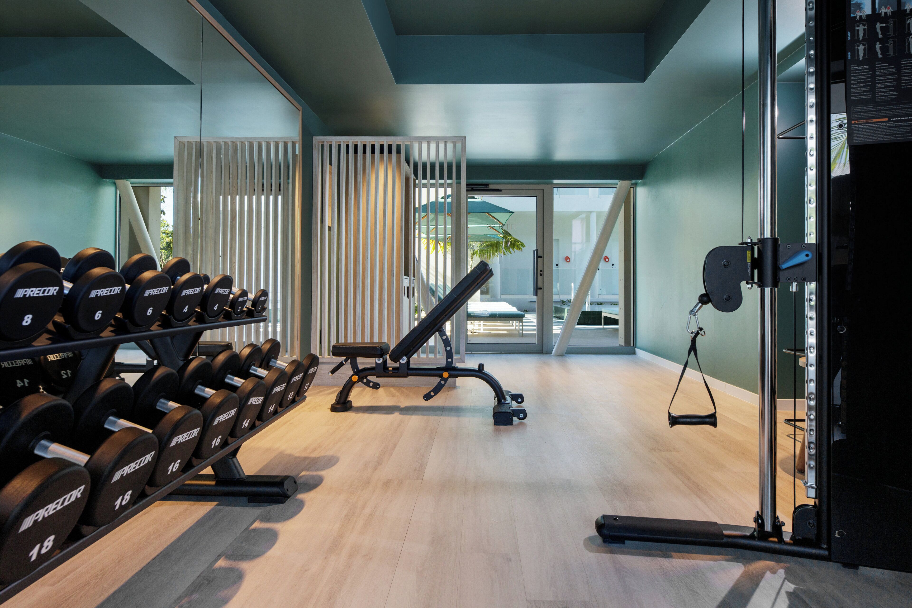 A gym with weightlifting equipment, a bench, and a pull-up bar.