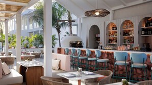 A restaurant with outdoor seating, a bar area, and a grill. - Hotel Indigo Turks Caicos Grace Bay by IHG (Providenciales)