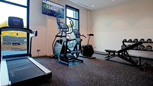 A gym with treadmills, an elliptical, a bench press, and a rack of dumbbells. - Holiday Inn Express & Suites Barcelona Sabadell by IHG (Sabadell)