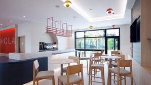 A modern cafe with a counter, seating area, and large windows. - Holiday Inn Express & Suites Barcelona Sabadell by IHG (Sabadell)