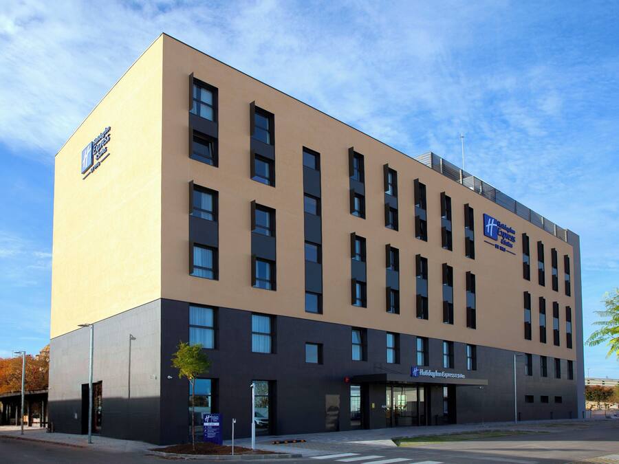 A modern hotel building with a flat facade, multiple windows, and a sign for 'Hilton Express'.
