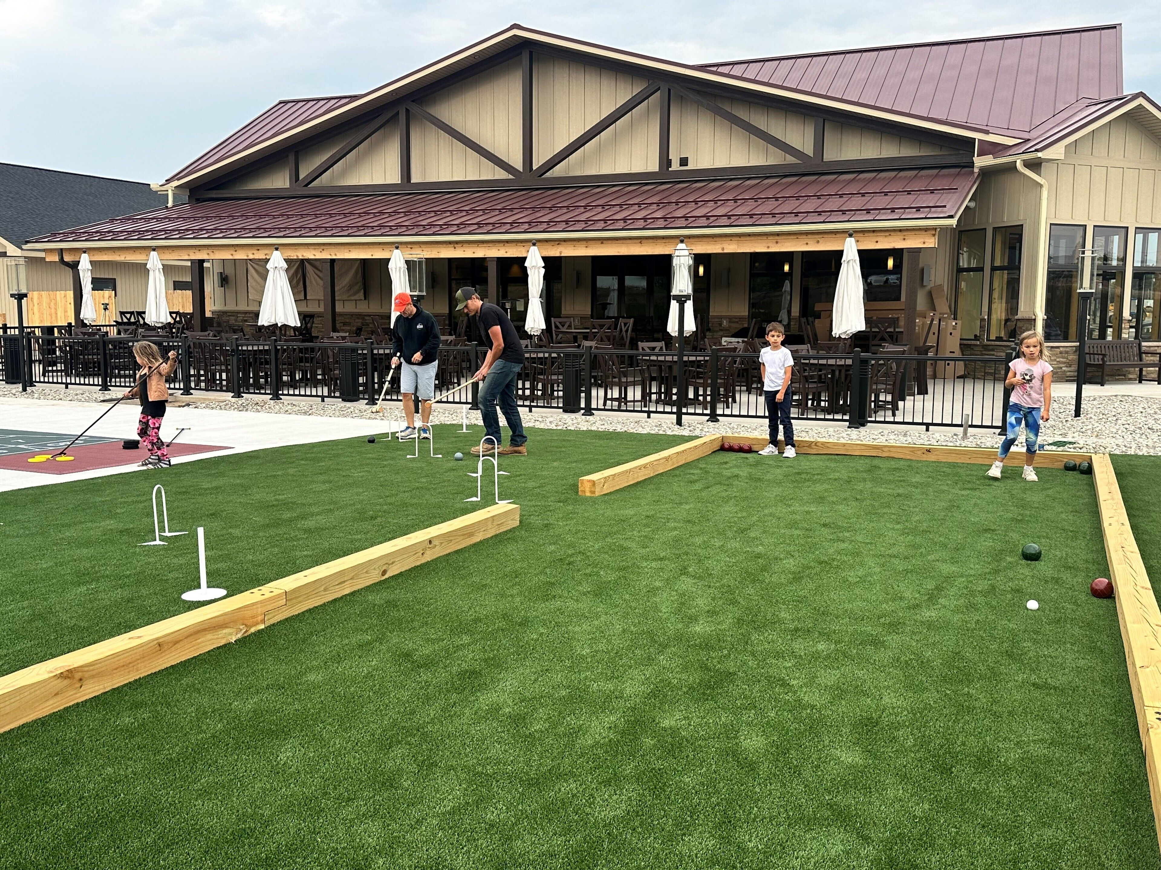 Un campo de croquet al aire libre con un edificio en el fondo.