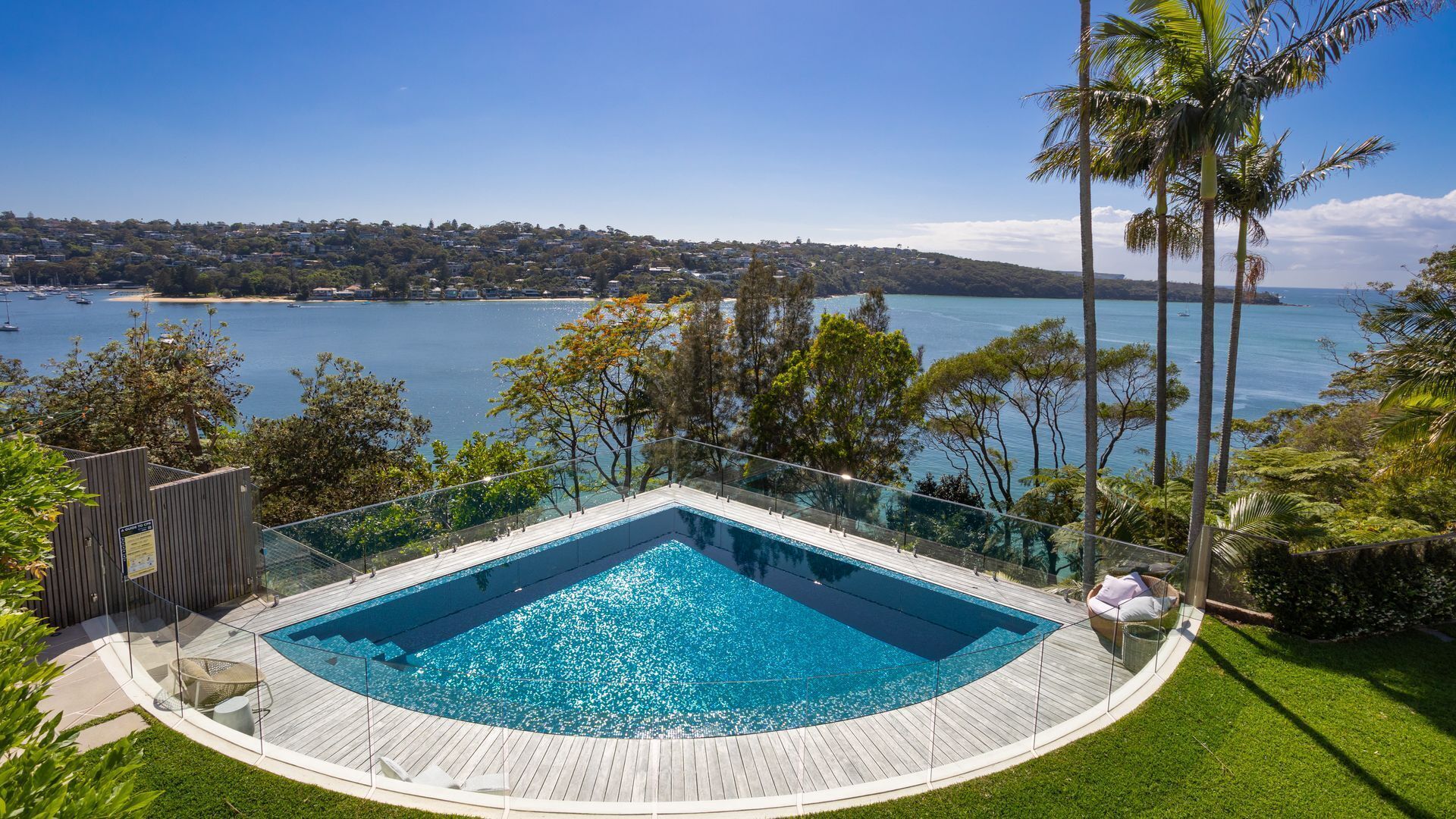 Una piscina circular infinita con vistas despejadas a una bahía y edificios lejanos.