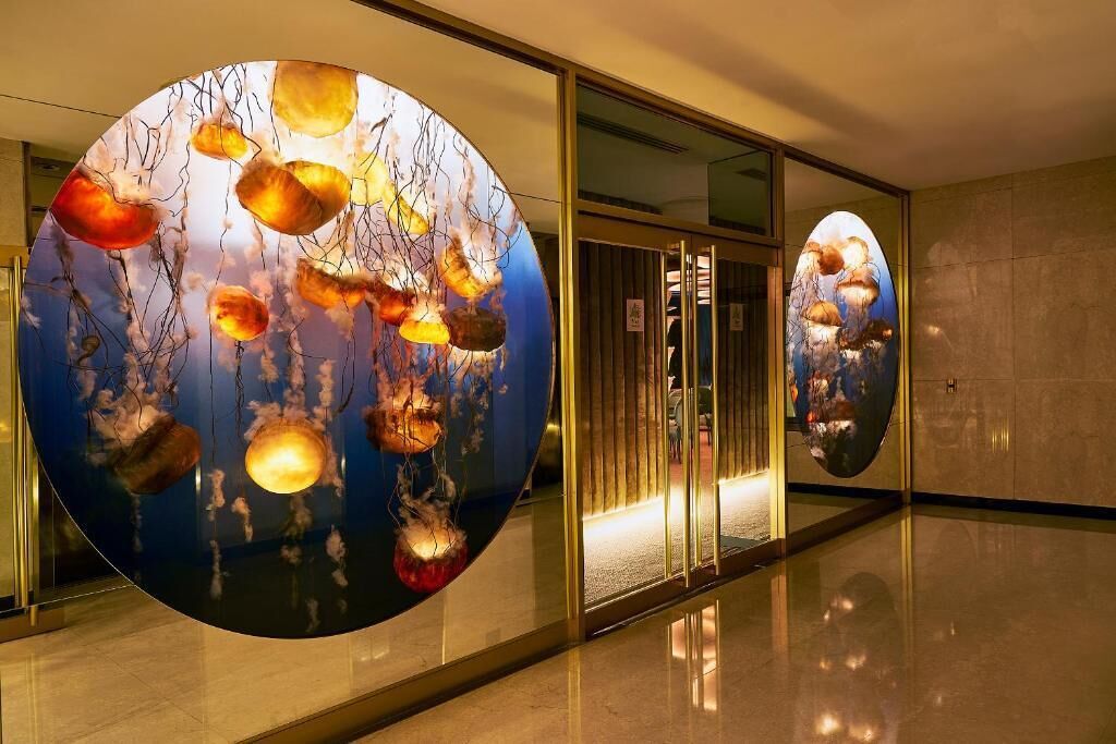 A hallway with a large circular artwork featuring abstract shapes and lines.