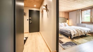 A bedroom with a bed, a window with curtains, and a wooden ceiling.