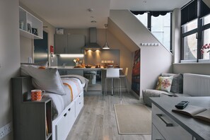Une cuisine moderne avec un coin repas, un canapé et une petite table avec une télécommande.