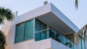 A modern two-story building with large glass windows and a balcony. - Casa Romero Cartagena Club de Playa (Cartagena)