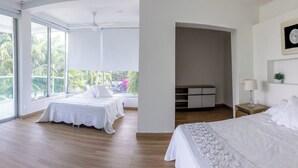 A hotel room with two beds, a desk, and a view of palm trees. - Casa Romero Cartagena Club de Playa (Cartagena)