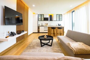 A modern living room with a flat-screen TV, a coffee table, and a sofa. - IAA Grande (Nyanyanu)
