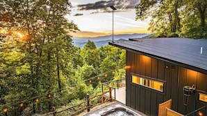 A modern cabin with a deck, a hot tub, and a scenic mountain view. - Sauna & Cold Plunge Cabin + Mountain Wellness Retreat (Bryson City)