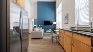 Una cocina moderna con refrigerador integrado, armarios de madera y encimera negra.
