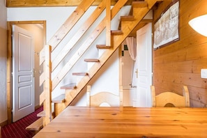 A wooden staircase leading to a bedroom with a bed and a bathroom visible in the background. - Resort center, 4th floor, balcony, 28m², La Plagne (La Plagne)