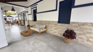 Un espace intérieur spacieux comprenant un canapé, une table ronde en bois et une plante en pot.