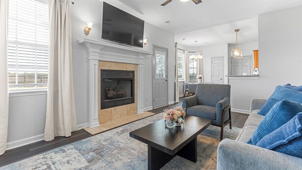 A living room with a fireplace, a television, a ceiling fan, and a sofa. - Spacious 5BR Retreat Sleeps 14 Huge Yard! (Warner Robins)