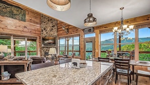 A spacious kitchen with granite countertops, a stone fireplace, and a large island. - Rustic 3bed Cabin w/ Perfect Views of The Smokies! (Gatlinburg)