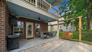 A covered patio area with a brick wall, a sliding glass door, outdoor furniture, and a pergola. - Charming 3-bedroom house in Lake Conroe, community pool and gym. (Montgomery)
