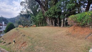 Un césped con un pequeño edificio y un sendero pavimentado que lo conduce.