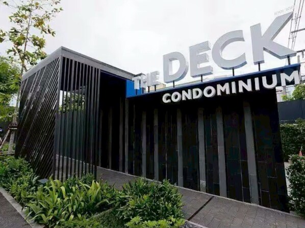 A modern building with a sign that reads "The Deck Condominium." - The Deck Patong Phuket by Mickey (Patong)