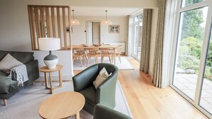Een moderne woonkamer met een bank, een salontafel en een eethoek met een tafel en stoelen.