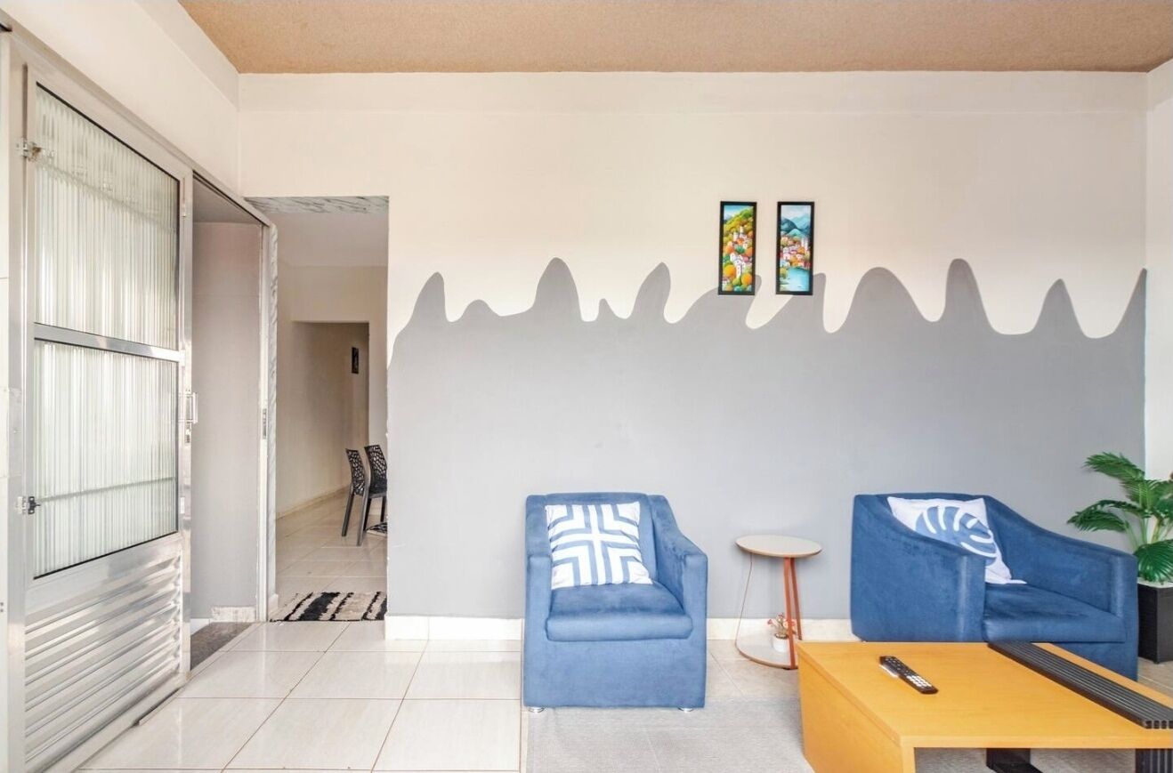 A modern living room with two blue sofas, a coffee table, and a small side table.