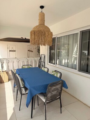Een eethoek met een tafel voor zes personen, omringd door stoelen.