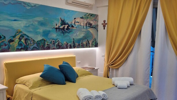 Ein Hotelzimmer mit einem Bett, einem Bild an der Wand und Vorhängen.