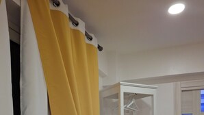 Ein Zimmer mit einem weißen Kleiderschrank, einem gelben Vorhang und einem weißen begehbaren Kleiderschrank.