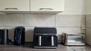 Eine Küche mit einer Kaffeemaschine, einem Toaster und einem Wasserkocher auf der Arbeitsfläche.