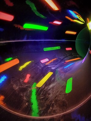 A circular structure with reflective surfaces and colorful light elements.