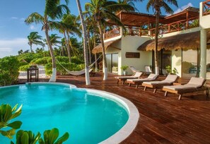 Una piscina al aire libre, sombrillas, tumbonas