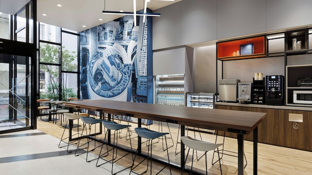 A modern kitchen with a long counter, bar stools, and built-in appliances. - Four Points Flex By Sheraton Tokyo Shibuya West (Tokyo)