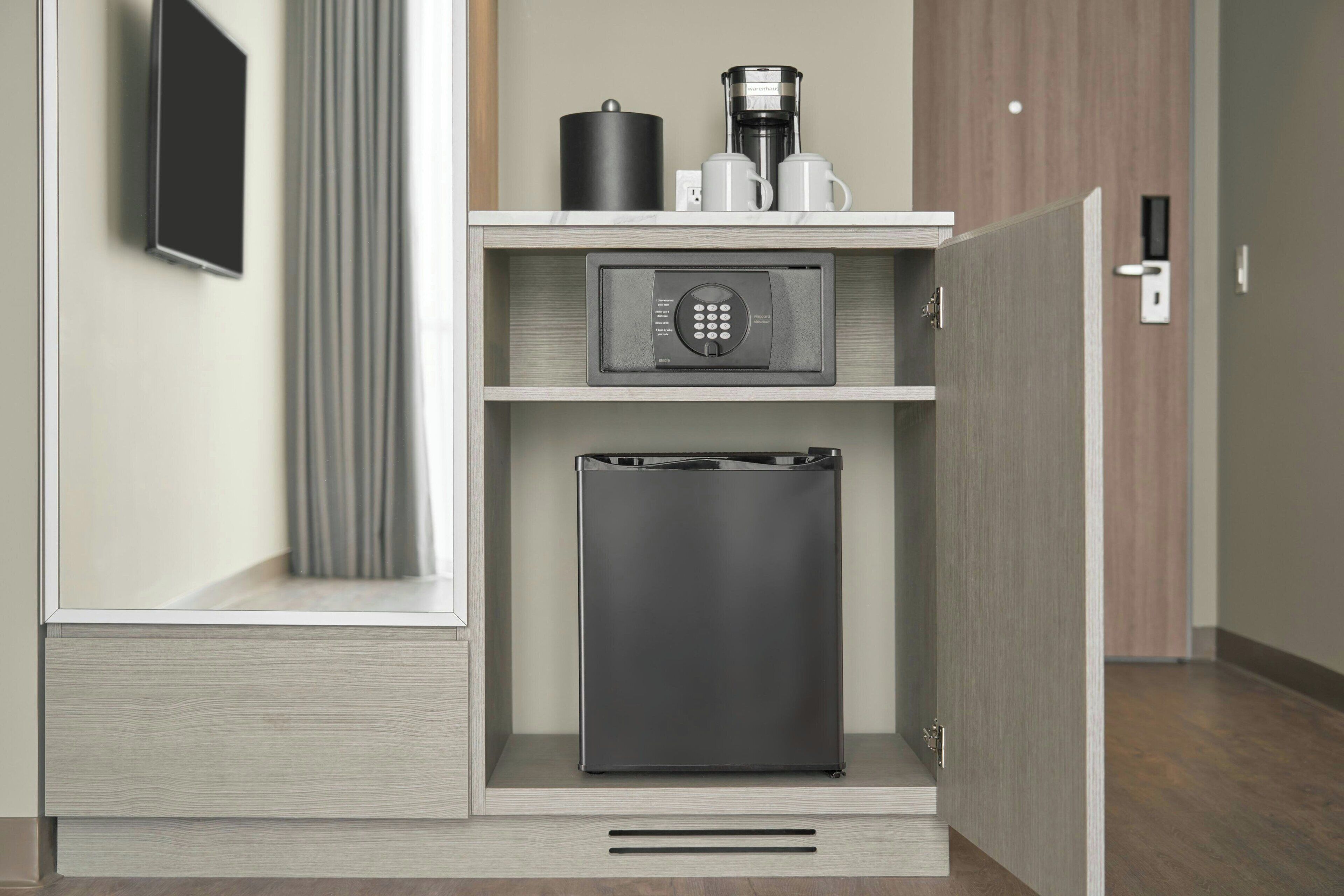 A compact minibar with a coffee maker, a microwave, and a refrigerator.