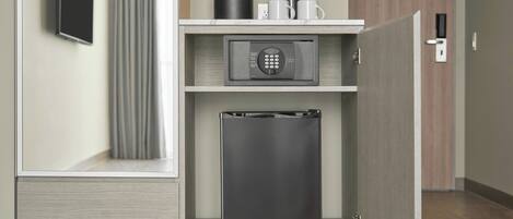 Un minibar compacto con cafetera, microondas y refrigerador.
