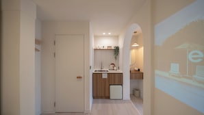 Een moderne keuken met een spoelbak, aanrecht en een kleine koelkast.