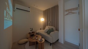 Een moderne woonkamer met een bank, salontafel en lamp.