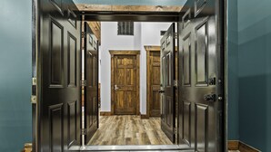 Un pasillo con puertas y piso de madera.