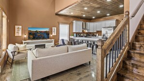 Un salón espacioso con un sofá grande, una zona de comedor y una cocina.