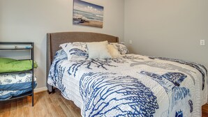 Ein Schlafzimmer mit einem Bett, einem Etagenbett und einem Bild an der Wand.