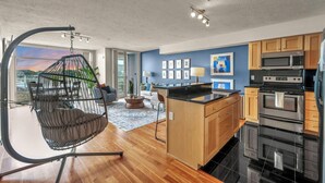 A modern kitchen with wooden cabinets, a black countertop, and stainless steel appliances.