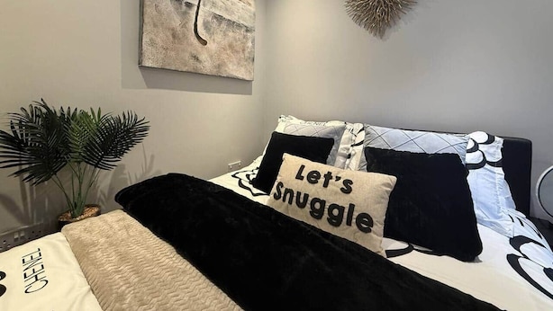 A bedroom with a bed, a potted plant, a wall art piece, and a decorative wall hanging. - Studio C - Newly renovated private 1 bed studio (Gamston)