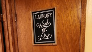 Une porte en bois avec une pancarte indiquant : « Laverie – lavage et séchage ».