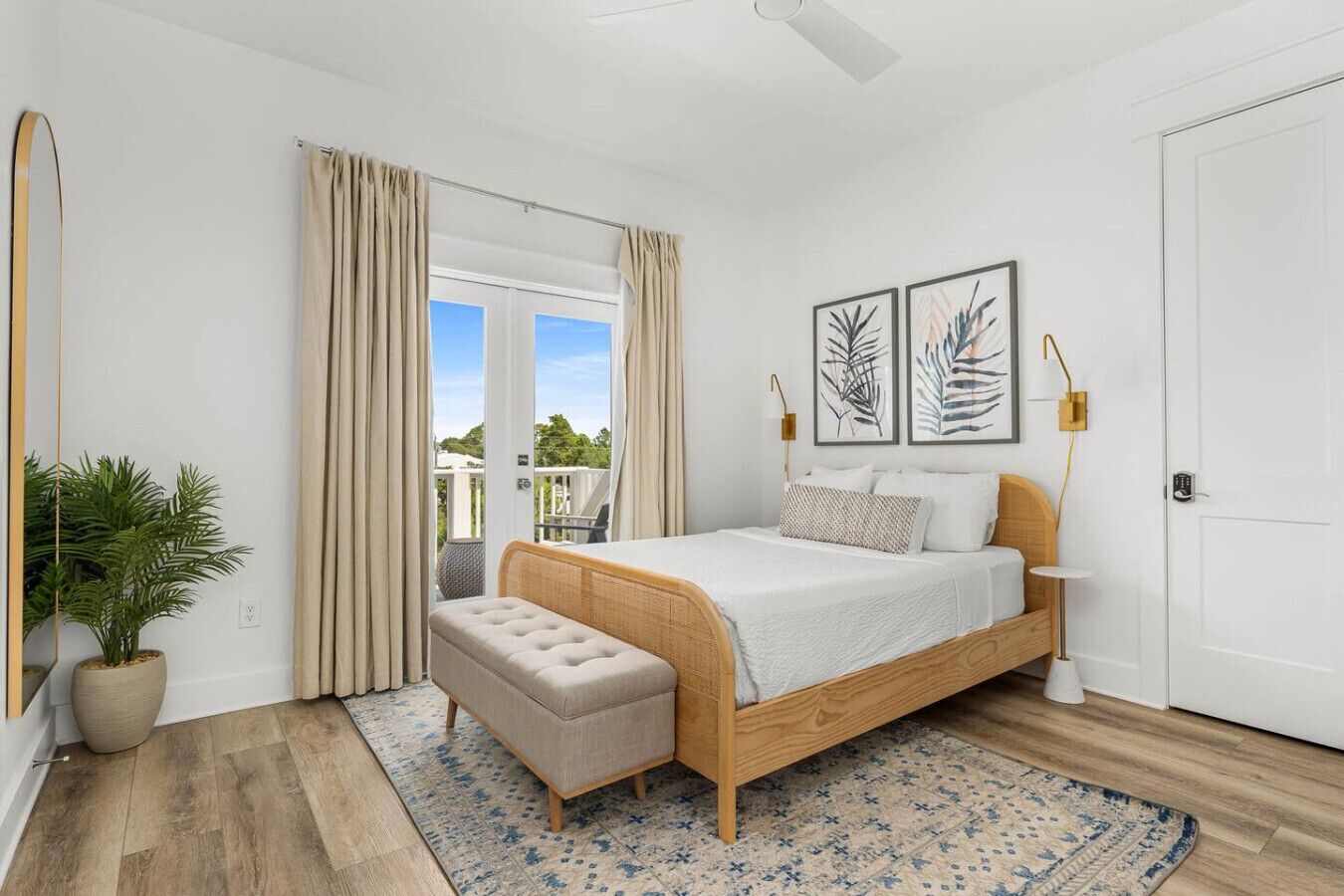 Un dormitorio con cama, un banco, una planta en maceta y vistas al exterior.