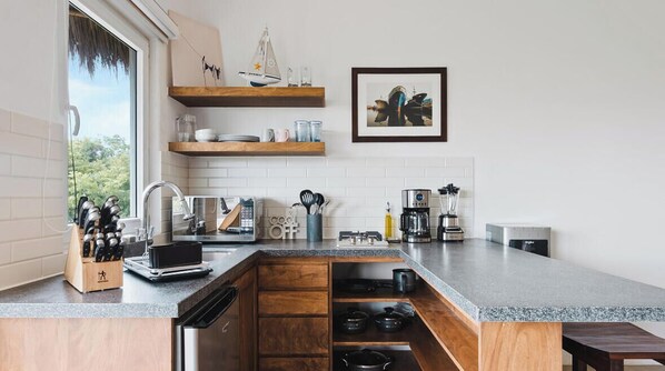 Eine moderne Küche mit Holzschränken, einer Granitarbeitsplatte und einem eingebauten Backofen.
