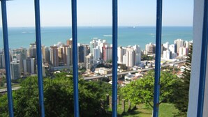 A cityscape with high-rise buildings, a bridge, and a body of water in the distance. - 4D5 Your Beach Retreat on the Coast Awaits You 1-minute-from-the-sea  (Vila Velha)